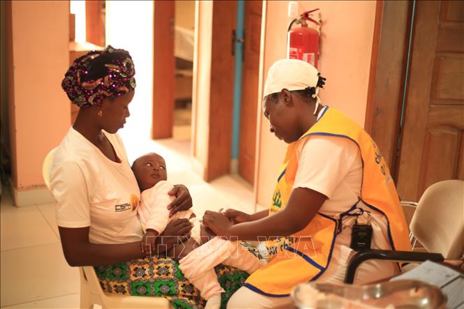 Nhân viên y tế tiêm vaccine phòng sốt rét cho em nhỏ tại Douala, Cameroon. Ảnh: THX/TTXVN
