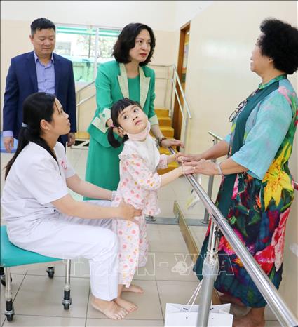 Thứ trưởng Bộ Y tế Nguyễn Thị Liên Hương thăm hỏi trẻ khuyết tật tại Trung tâm Điều dưỡng, Phục hồi chức năng-Trợ giúp trẻ em và hỗ trợ người khuyết tật. Ảnh: Thanh Vũ-TTXVN
