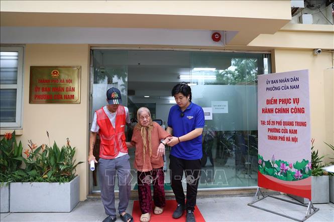 Lực lượng tình nguyện hỗ trợ người dân làm thủ tục hành chính tại Điểm phục vụ hành chính công phường Cửa Nam, thành phố Hà Nội. Ảnh: Quốc Lũy – TTXVN