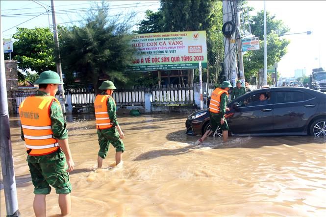 Lực lượng bộ đội Đồn biên phòng Thanh Hải hỗ trợ người dân lưu thông qua tuyến đường Nguyễn Thông, phường Phú Thủy (Lâm Đồng). Ảnh: Hồng Hiếu - TTXVN