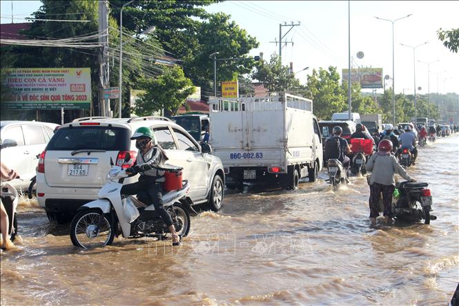 Các phương tiện lưu thông khó khăn trên tuyến đường Nguyễn Thông (phường Phú Thủy, tỉnh Lâm Đồng) do  ngập sâu. Ảnh: Hồng Hiếu - TTXVN