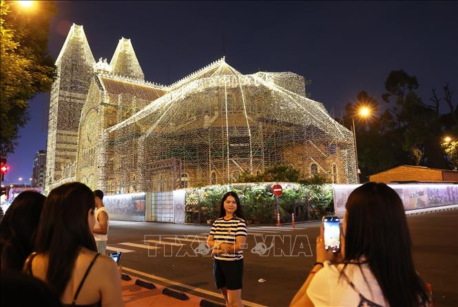 Khách du lịch check-in tại Nhà thờ Đức Bà TP. Hồ Chí Minh. Ảnh: Hồng Đạt - TTXVN 
