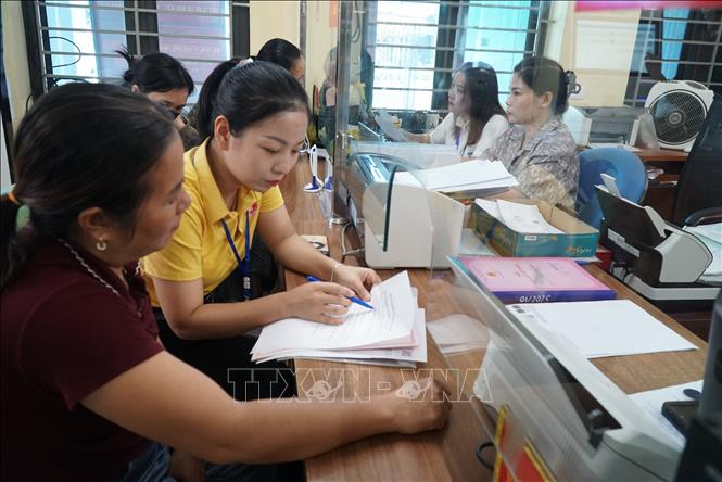 Tổ chuyển đổi số cộng đồng các xã miền núi Nghệ An hướng dẫn người dân cách sử dụng điện thoại thông minh để truy cập và thực hiện các bước kê khai trên cổng dịch vụ công quốc gia. Ảnh: Bích Huệ - TTXVN                             