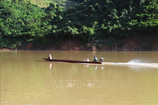 Người dân xuôi hạ nguồn sông Nậm Nơn bằng thuyền máy nhỏ để về lòng hồ thủy điện Bản Vẽ vớt gỗ. Ảnh: Xuân Tiến - TTXVN 