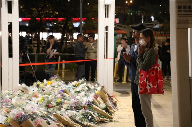 Người dân đặt hoa tưởng niệm các nạn nhân trong vụ cháy chung cư tại Tai Po, Hong Kong (Trung Quốc). Ảnh: Yonhap/TTXVN