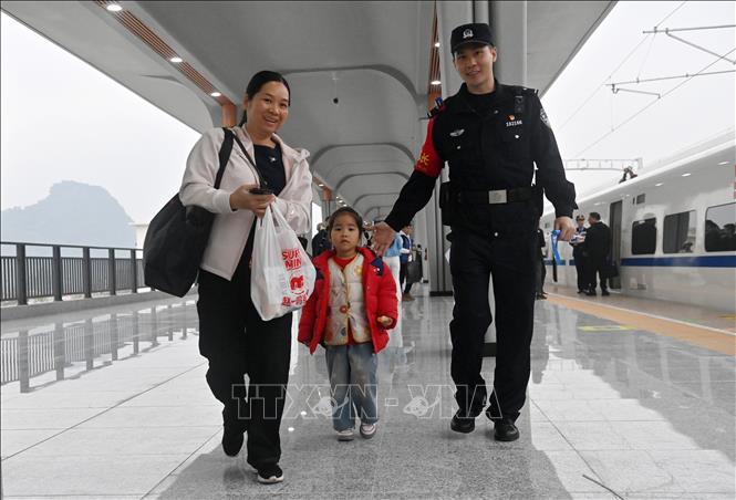 Nhân viên đường sắt hướng dẫn hành khách lên tàu tại nhà ga ở Bằng Tường, Khu tự trị dân tộc Choang Quảng Tây, Trung Quốc, ngày 5/12/2025. Ảnh: THX/TTXVN