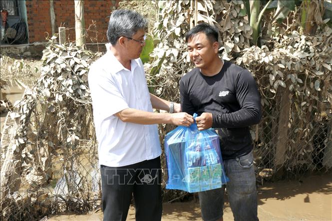 Phó Chủ tịch UBND tỉnh Lâm Đồng Nguyễn Minh tặng quà, động viên người dân bị thiệt hại do ngập lụt tại xã Bắc Bình. Ảnh: Nguyễn Thanh - TTXVN