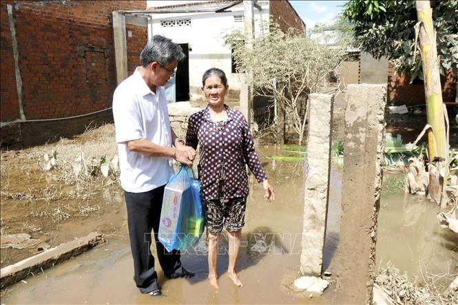 Phó Chủ tịch UBND tỉnh Lâm Đồng Nguyễn Minh tặng quà, động viên người dân bị thiệt hại do ngập lụt tại xã Bắc Bình. Ảnh: Nguyễn Thanh - TTXVN
