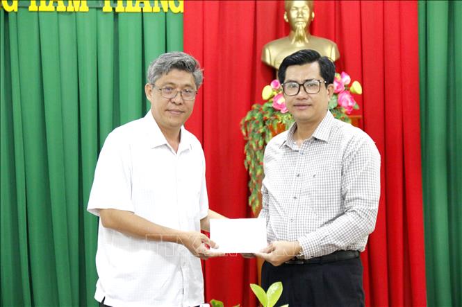 Phó Chủ tịch UBND tỉnh Lâm Đồng Nguyễn Minh (bên trái) trao hỗ trợ thiệt hại cho phường Hàm Thắng. Ảnh: Nguyễn Thanh - TTXVN