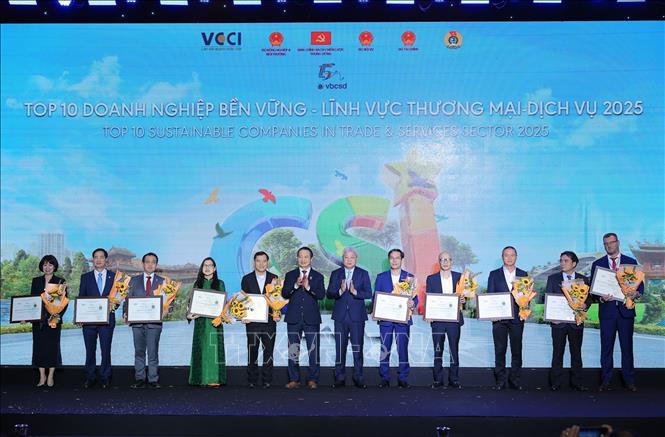 Ông Nguyễn Mạnh Khương, Thứ trưởng Bộ Nội vụ và Phó Chủ tịch VCCI Nguyễn Quang Vinh trao hoa và chứng nhận cho Doanh nghiệp bền vững trong lĩnh vực thương mại – dịch vụ năm 2025. Ảnh: Lê Đông - TTXVN