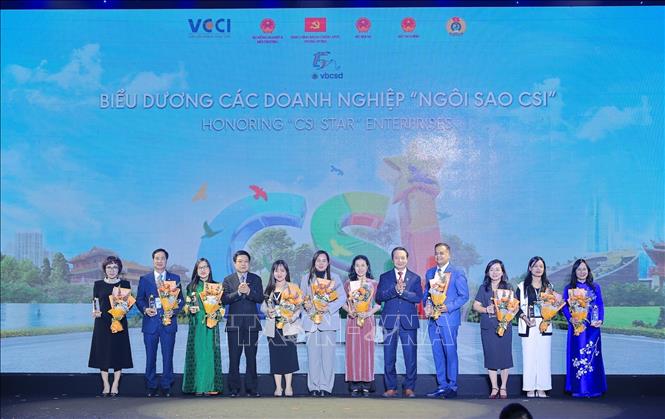 Chủ tịch VCCI Hồ Sỹ Hùng và Phó Chủ tịch VCCI Nguyễn Quang Vinh trao hoa và cúp Ngôi sao CSI cho các doanh nghiệp. Ảnh: Lê Đông - TTXVN
