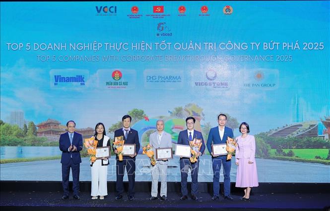 Cục trưởng Cục Phát triển doanh nghiệp tư nhân và Kinh tế tập thể Bùi Anh Tuấn và Phó Tổng giám đốc Deloitte Việt Nam Phạm Quỳnh Hoa trao hoa và chứng nhận cho Doanh nghiệp thực hiện tốt quản trị công ty bứt phá năm 2025. Ảnh: Lê Đông - TTXVN