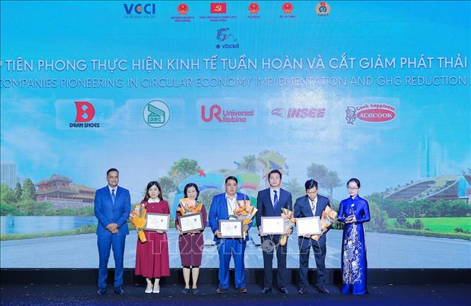 Tổng Thư ký VCCI Trần Thị Lan Anh và Đồng Chủ tịch VBCSD Binu Jacob trao hoa và chứng nhận cho Doanh nghiệp tiên phong thực hiện kinh tế tuần hoàn và cắt giảm phát thải khí nhà kính năm 2025. Ảnh: Lê Đông - TTXVN