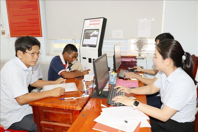 Người dân làm hồ sơ thủ tục hành chính tại Trung tâm Phục vụ hành chính công xã Nha Bích. Ảnh: K GỬIH-TTXVN 