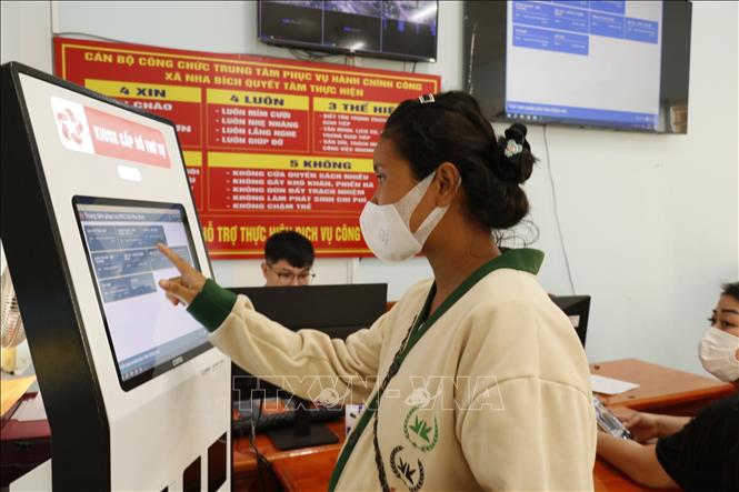 Người dân đăng ký thủ tục hành chính công trực tuyến tại Trung tâm phục vụ hành chính công xã Nha Bích. Ảnh: K GỬIH-TTXVN 