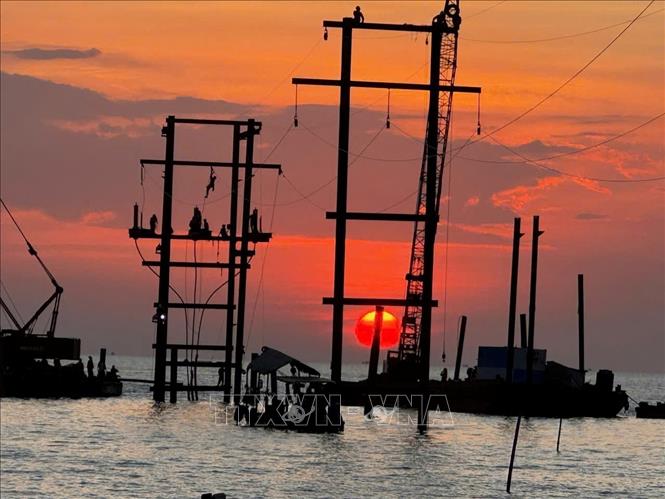 Công ty Điện lực An Giang thi công đường dây 110kV trên không với 4 khoảng trụ khắc phục sự cố cáp ngầm 110kV Hà Tiên - Phú Quốc. Ảnh: TTXVN phát