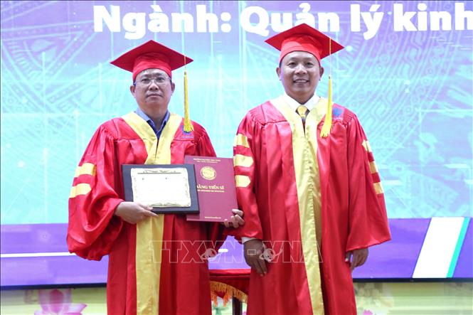 Phó Giáo sư, Tiến sĩ Nguyễn Minh Hòa, Hiệu trưởng Trường Đại học Trà Vinh trao bằng tiến sĩ cho học viên. Ảnh: Thanh Hòa-TTXVN