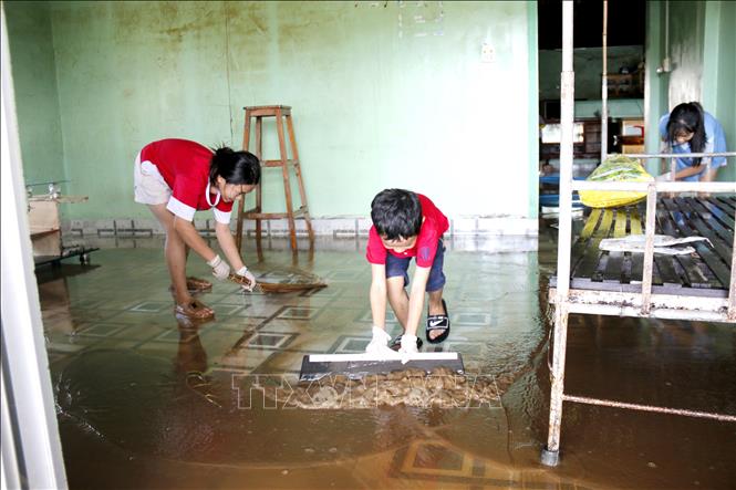 Người dân phường Hàm Thắng (Lâm Đồng) dọn dẹp nhà cửa sau lũ. Ảnh: Nguyễn Thanh - TTXVN
