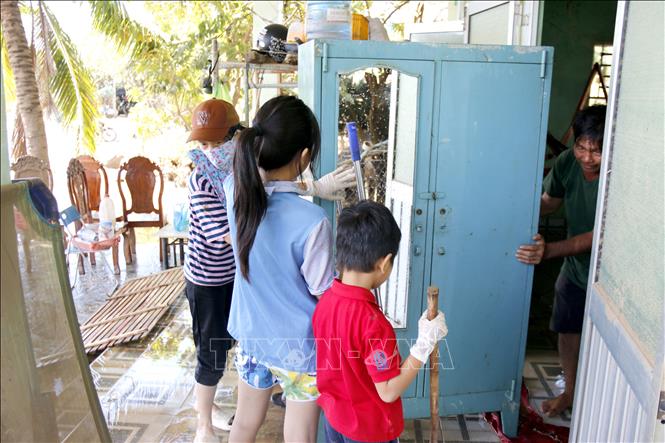 Người dân phường Hàm Thắng (Lâm Đồng) dọn dẹp nhà cửa sau lũ. Ảnh: Nguyễn Thanh - TTXVN