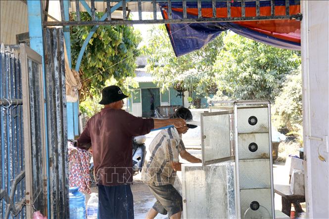 Người dân phường Hàm Thắng (Lâm Đồng) dọn dẹp nhà cửa sau lũ. Ảnh: Nguyễn Thanh - TTXVN