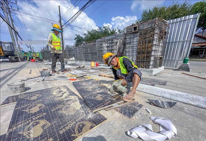 Công nhân thi công các hạng mục Dự án nâng cấp, mở rộng Quốc lộ 91 (đoạn từ Km0 - Km7) đoạn qua địa bàn phường Bình Thủy ngày 6/12/2025. Ảnh: Thanh Liêm - TTXVN