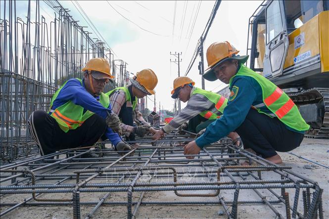 Công nhân thi công cấu kiện đúc sẵn của hệ thống thoát nước thải Dự án nâng cấp, mở rộng 7km Quốc lộ 91. Ảnh: Thanh Liêm - TTXVN