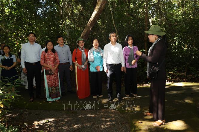 Phó Trưởng Ban Tuyên giáo và Dân vận Trung ương Ngô Đông Hải (áo trắng, đứng thứ 3 từ phải sang) cùng các đại biểu tham quan nhà phục dựng khu làm việc của các đồng chí lãnh đạo Trung ương Cục miền Nam thời kháng chiến. Ảnh: Thanh Tân - TTXVN