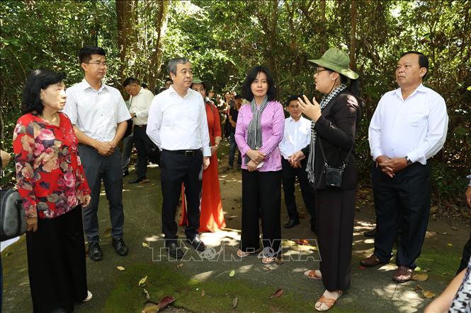 Các đại biểu tham quan nhà phục dựng khu làm việc của các đồng chí lãnh đạo Trung ương Cục miền Nam thời kháng chiến. Ảnh: Thanh Tân - TTXVN