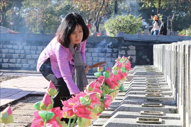 Đồng chí Nguyễn Thị Xuân Hương, Trưởng Ban Tuyên giáo và Dân vận Tỉnh ủy Tây Ninh thắp hương tại phần mộ các anh hùng liệt sĩ ở Nghĩa trang liệt sĩ Đồi 82. Ảnh: Thanh Tân - TTXVN