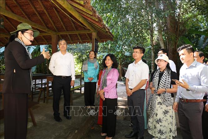 Đồng chí Ngô Đông Hải, Phó Trưởng Ban Tuyên giáo và Dân vận Trung ương (áo trắng, đứng thứ 2 từ trái sang) cùng các đại biểu tham quan nhà phục dựng khu làm việc của các đồng chí lãnh đạo Trung ương Cục miền Nam thời kháng chiến. Ảnh: Thanh Tân - TTXVN