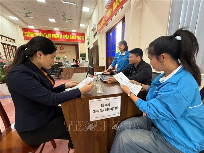 Đoàn viên, thanh niên thực hiện mô hình “Ngày không viết” hướng dẫn thủ tục cho người dân. Ảnh: Tiến Vĩnh – TTXVN 

