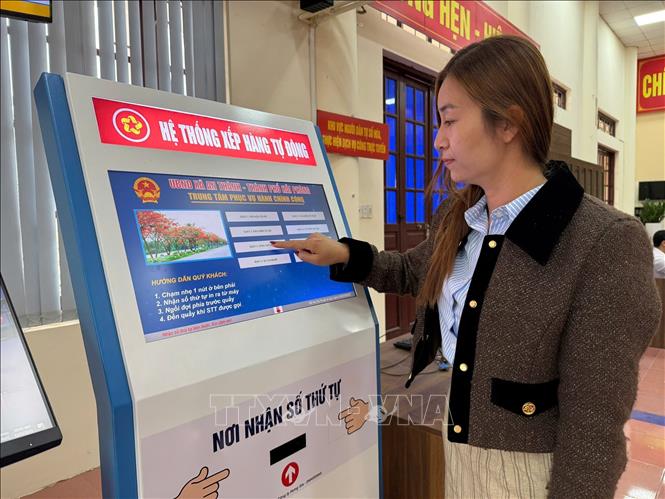 Người dân lấy số thứ tự tại Trung tâm phục vụ hành chính công tại xã An Thành. Ảnh: Tiến Vĩnh – TTXVN