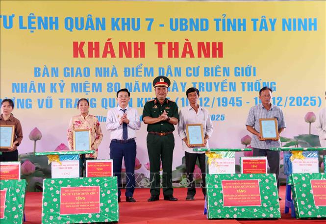 Thiếu tướng Lê Xuân Thế, Tư lệnh Quân khu 7 và đại diện lãnh đạo tỉnh Tây Ninh tặng quà cho người dân được nhận nhà mới trong dự án Điểm dân cư liền kề chốt dân quân biên giới tỉnh Tây Ninh. Ảnh: Xuân Khu-TTXVN