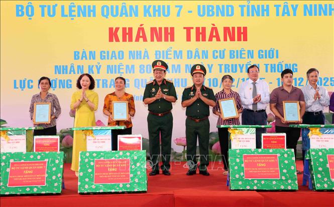 Thượng tướng Võ Minh Lương, Thứ trưởng Bộ Quốc phòng và Thiếu tướng Trần Vinh Ngọc, Chính ủy Quân khu 7 tặng quà cho người dân được nhận nhà mới trong dự án Điểm dân cư liền kề chốt dân quân biên giới tỉnh Tây Ninh. Ảnh: Xuân Khu-TTXVN
