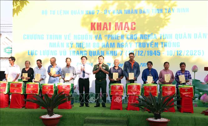 Thiếu tướng Trần Vinh Ngọc, Chính ủy Quân khu 7 cùng đại diện lãnh đạo tỉnh Tây Ninh tặng quà cho người dân xã Đức Huệ. Ảnh: Xuân Khu-TTXVN