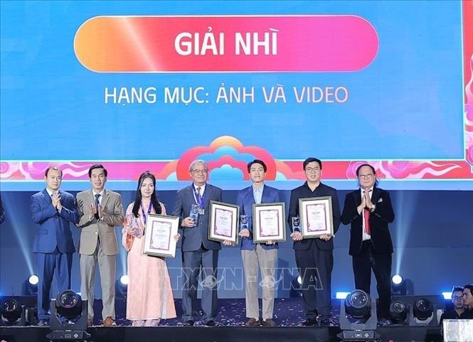Thứ trưởng Thường trực Bộ Văn hóa, Thể thao và Du lịch Lê Hải Bình, Chủ tịch Hội Điện ảnh Việt Nam Đỗ Lệnh Hùng Tú và Tổng Biên tập Tạp chí Nhiếp ảnh và Đời sống Hồ Sỹ Minh trao kỷ niệm chương và giấy chứng nhận cho các tác giả đạt Giải Nhì. Ảnh: Lê Đông - TTXVN