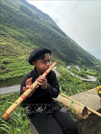 A Mong boy plays a flute along the road leading to Lung Cam valley. VNA Photo: Minh Tâm