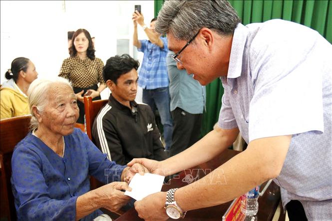 Ông Nguyễn Minh, Phó Chủ tịch UBND tỉnh Lâm Đồng trao quà hỗ trợ cho người dân xã Hàm Liêm bị thiệt hại nặng do mưa lũ gây ra. Ảnh: Nguyễn Thanh - TTXVN
