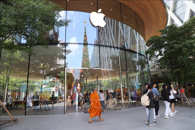 Cây thông Noel in bóng lên cửa hàng Apple trong Trung tâm thương mại Central World ở Bangkok. Ảnh: Đỗ Sinh - PV TTXVN tại Thái Lan 