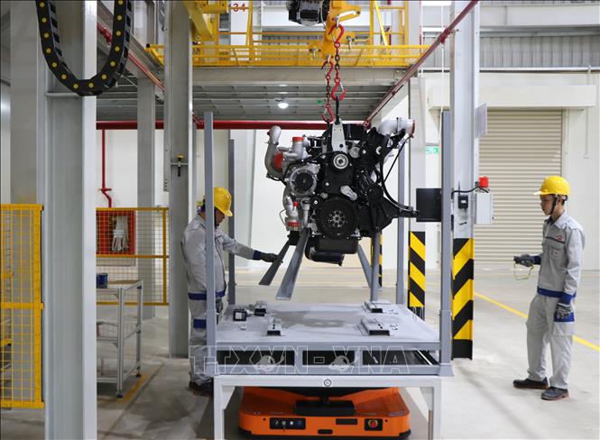 Công nhân Công ty Kim Long Motor Huế thực hiện quy trình sản xuất động cơ. Ảnh: Nguyên Lý - TTXVN