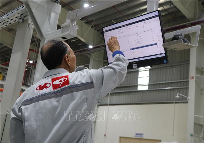 Công nhân Công ty Kim Long Motor Huế thực hiện quy trình sản xuất động cơ trên máy tính. Ảnh: Nguyên Lý - TTXVN