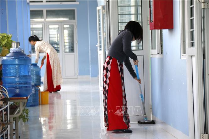 Các cô giáo Trường tiểu học Lâm Hưng tranh thủ dọn dẹp vệ sinh trường lớp trước khi vào lớp. Ảnh: Hồng Hiếu- TTXVN