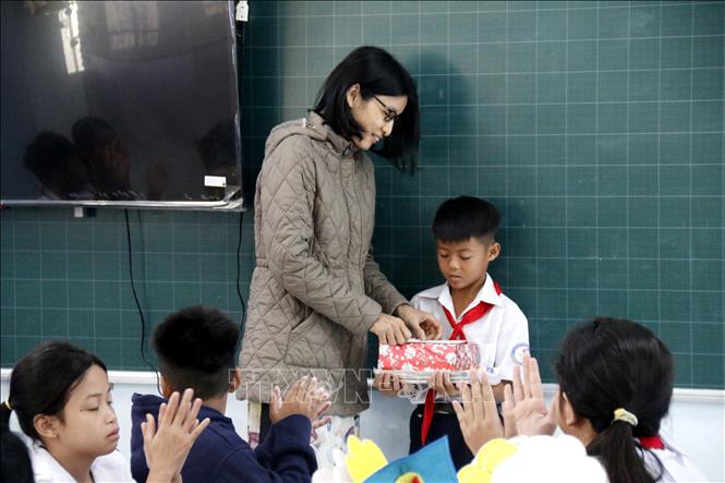 Cô giáo chủ nhiệm trao quà cho em Nguyễn Anh Tín, học sinh lớp 5D Trường tiểu học Lâm Hưng, bị thiệt hại nặng do mưa lũ. Ảnh: Hồng Hiếu- TTXVN