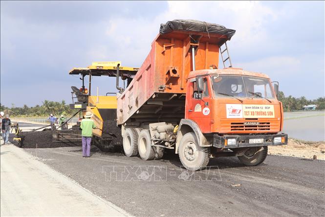 Đơn vị thi công thảm bê tông nhựa tại các tuyến nối trên cao tốc. Ảnh: Tuấn Phi - TTXVN