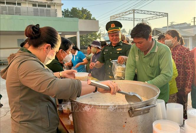 Những bát cháo nóng hổi, thơm lừng, được cán bộ, chiến sĩ Đồn Biên phòng Vĩnh Nguơn (Ban chỉ huy Bộ đội Biên phòng tỉnh An Giang) cẩn thận cho vào hộp nhựa trao tận tay người bệnh và người nhà bệnh nhân nghèo đang điều trị tại Bệnh viện Đa khoa Châu Đốc, tỉnh An Giang. Ảnh: Công Mạo-TTXVN