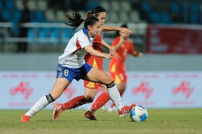 Pha tranh cướp bóng giữa đội trưởng Hải Yên (số 12, Việt Nam) và cầu thủ Kristine (số 8, Philippines). Ảnh: Minh Quyết - PV TTXVN tại Thái Lan