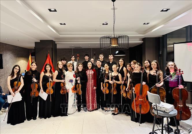 Đại sứ Nguyễn Thị Minh Nguyệt chụp ảnh cùng nhạc trưởng Lê Phi Phi và dàn nhạc. Ảnh: TTXVN Phát