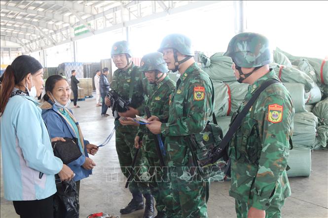 Bộ đội Biên phòng cửa khẩu Chi Ma tuyên truyền pháp luật biên giới tới người lao động trong khu bãi hàng hóa. Ảnh: Quang Duy  - TTXVN