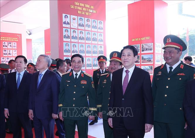 Chủ tịch nước Lương Cường và các đại biểu tham quan trưng bày kỷ niệm 80 năm Ngày truyền thống Lực lượng vũ trang Quân khu 7. Ảnh: Lâm Khánh - TTXVN