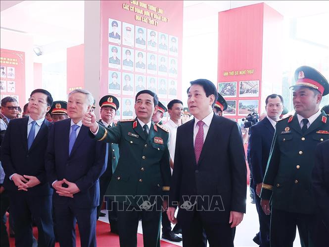 Chủ tịch nước Lương Cường và các đại biểu tham quan trưng bày kỷ niệm 80 năm Ngày truyền thống Lực lượng vũ trang Quân khu 7. Ảnh: Lâm Khánh - TTXVN